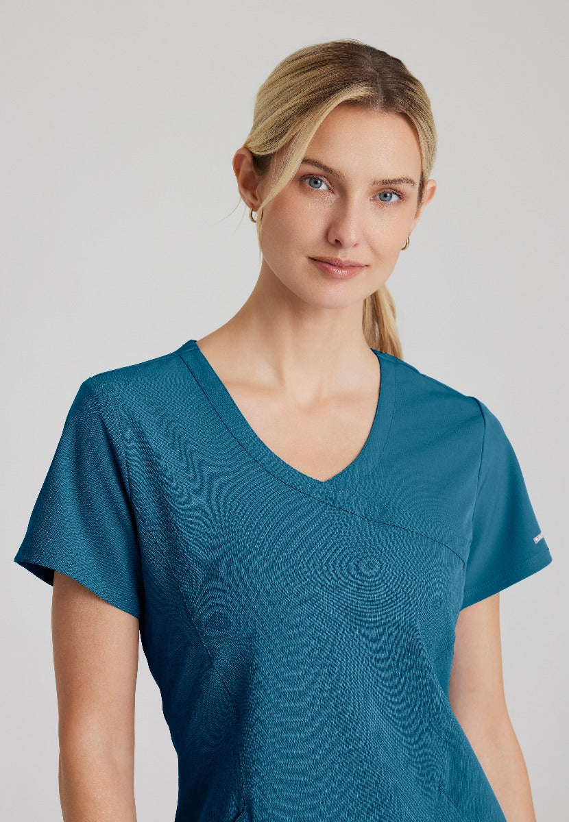 SKECHERS FEMALE RELIANCE 3-POCKET WRAP EFFECT TOP | Bahama / Caribbean